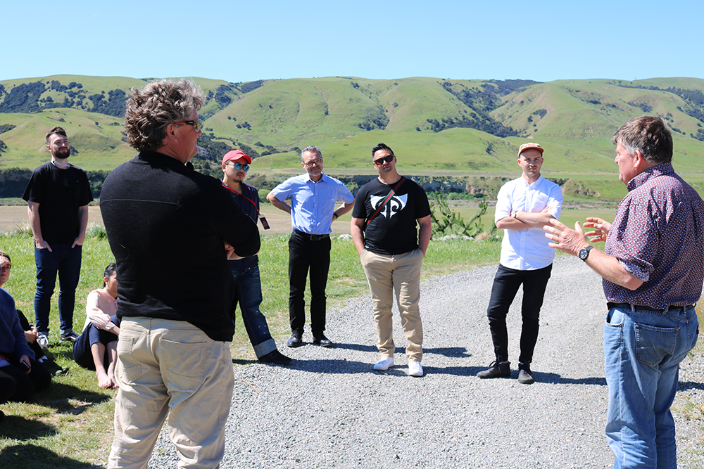 The vineyard owner talking to the group on a gravel driveway
