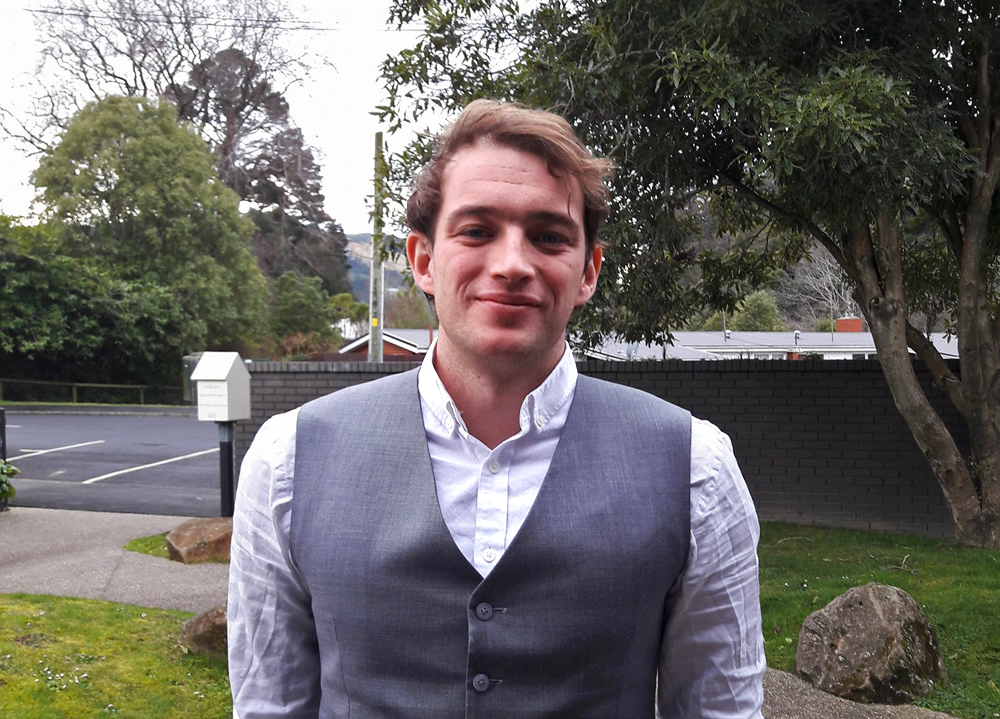 A portrait photo of Paul standing outside