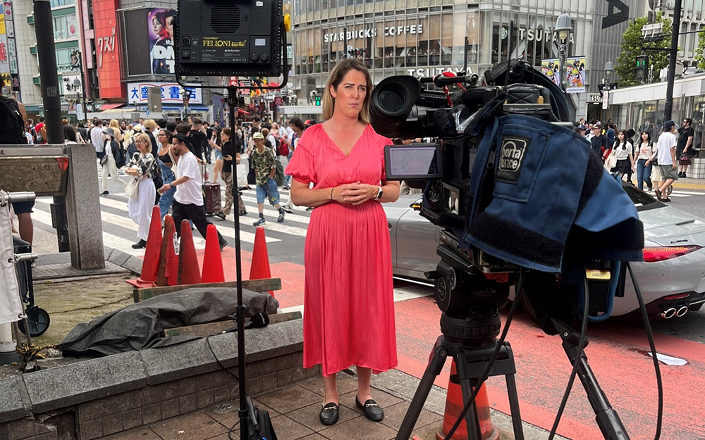 Juliet Speedy speaking to the camera from Shibuya Crossing