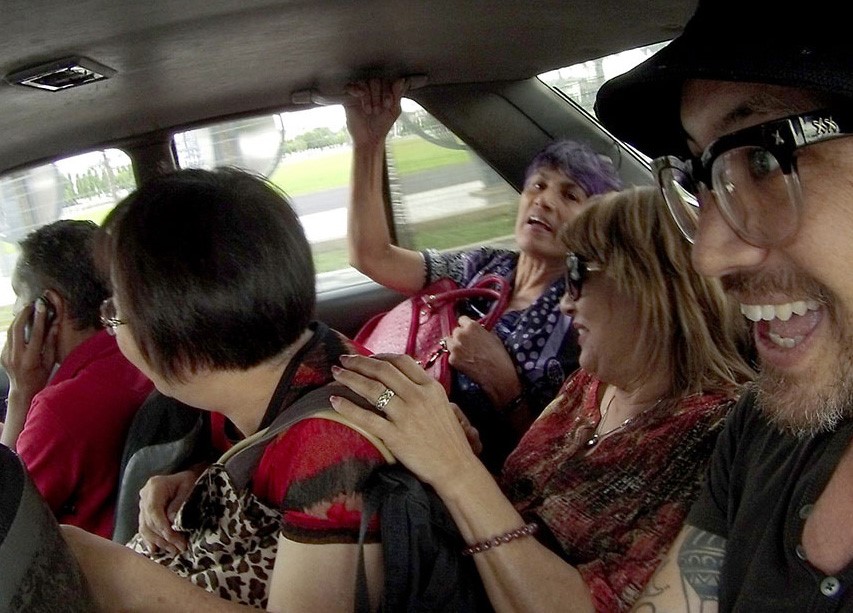 Crowd of people in the backseat of a car
