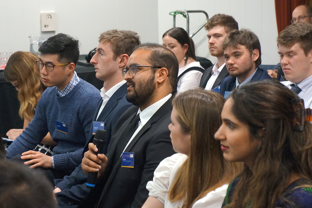 Vinod holding a microphone and putting a question to a speaker