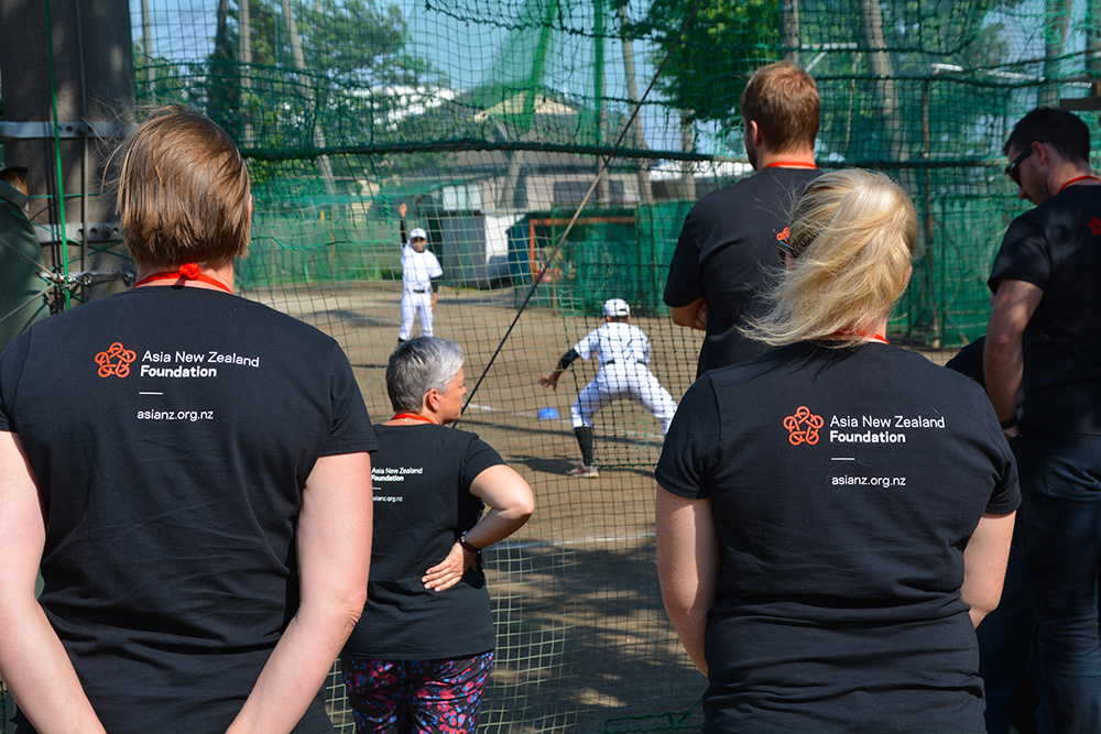 Teachers watching boys playing baseball