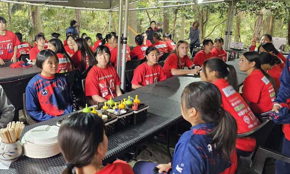 Girls in their school uniforms sitting at tables waiting for lunch