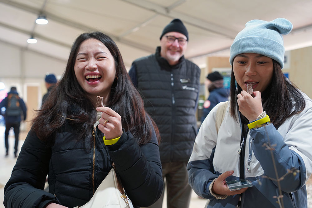 Two of the visiting Southeast Asian entrepreneurs trying chocolate fish for the first time
