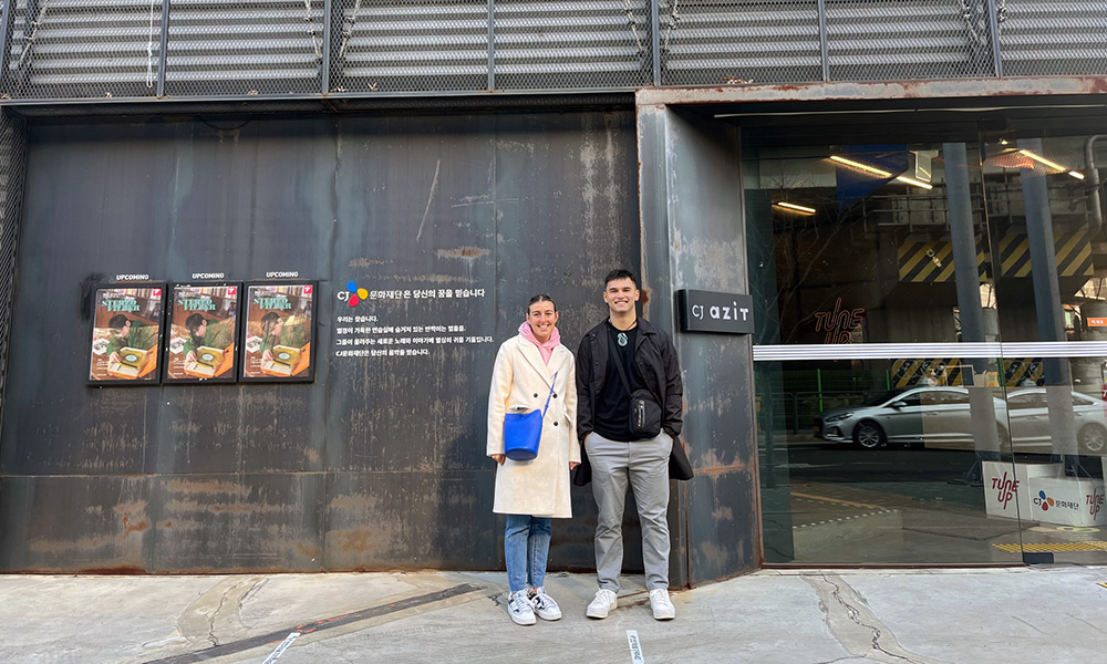 Brigham and Libby standing on the street outside CJ Azit's premises in Seoul South Korea