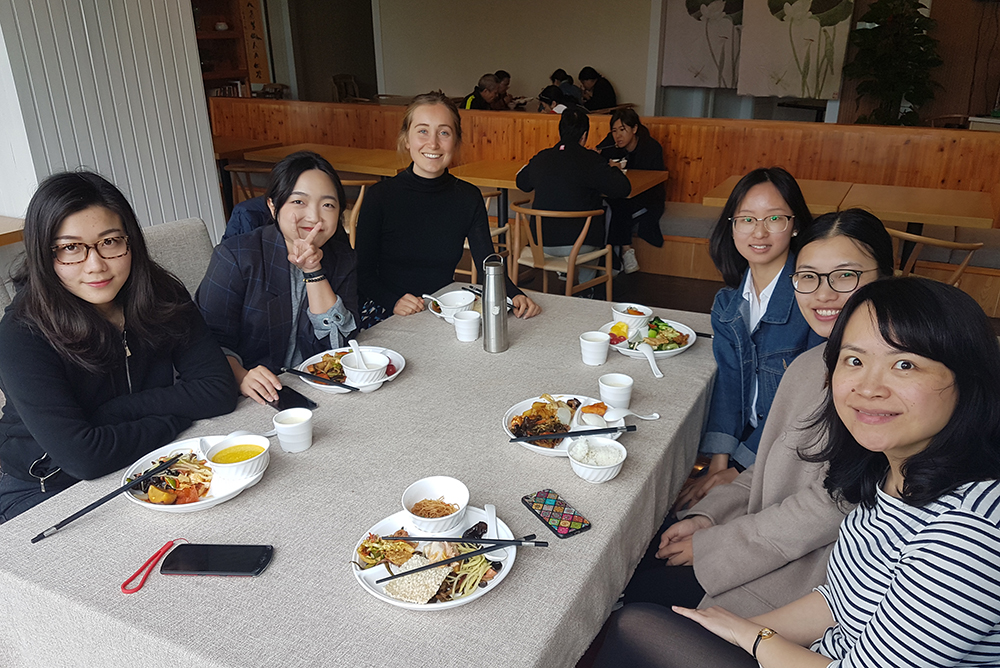 Cleo sitting at a table eating a meal with a group of colleagues