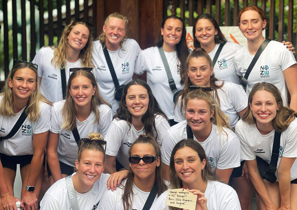 The whole team wearing white t-shirts and posing for a photo
