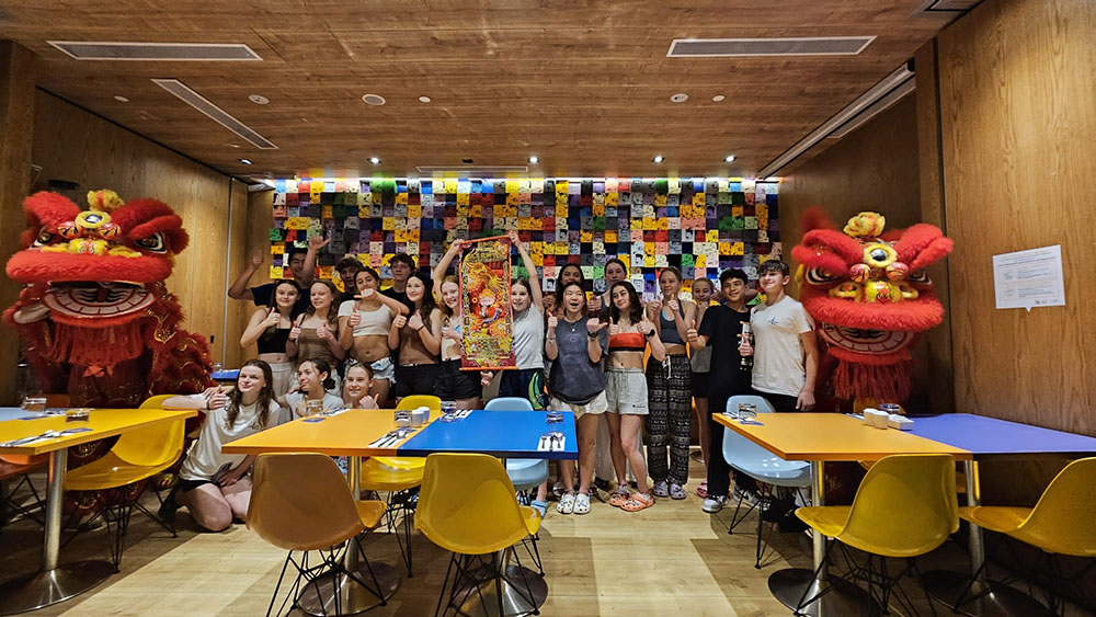 The divers in a room with lion dance lions on either side of the group