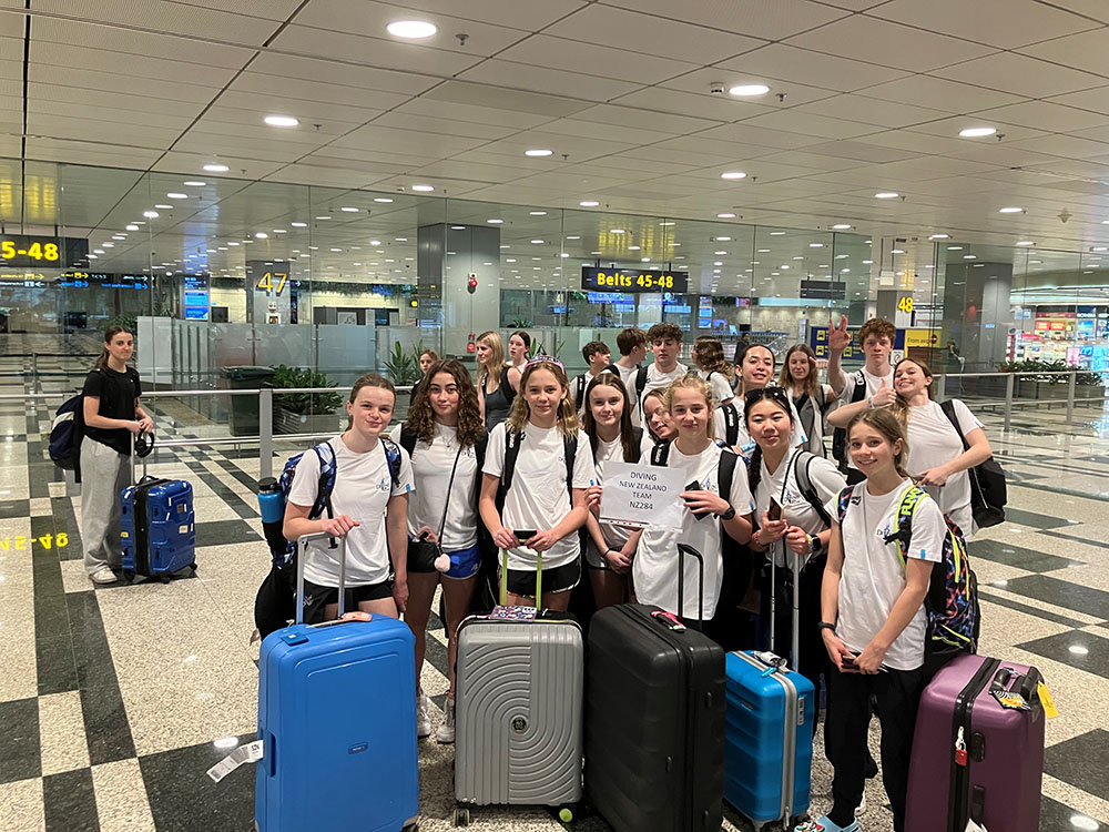 The team gathered for a group photo in an airport terminal