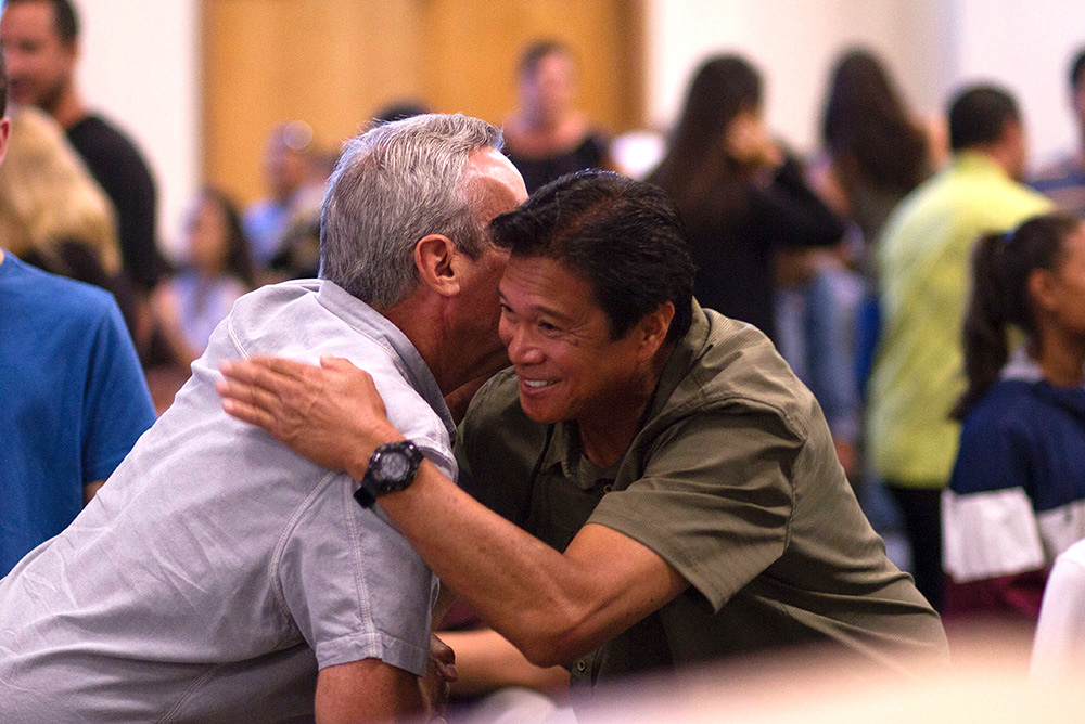 Two men shaking hands/hugging