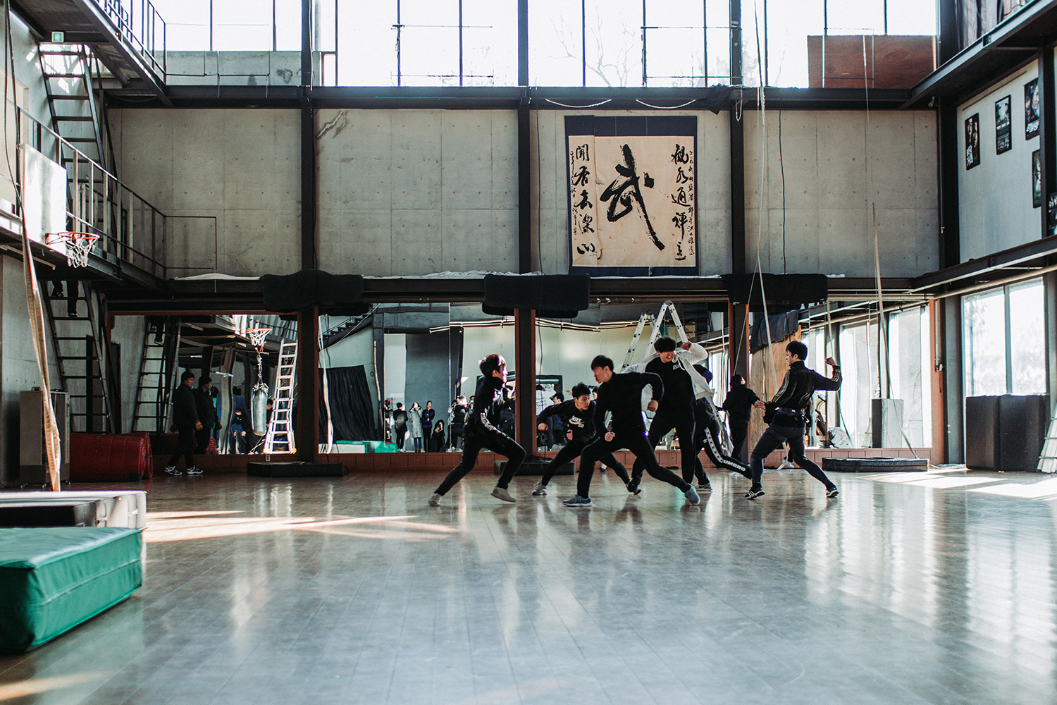 A group of stunt people performing a martial acts routine in a studio