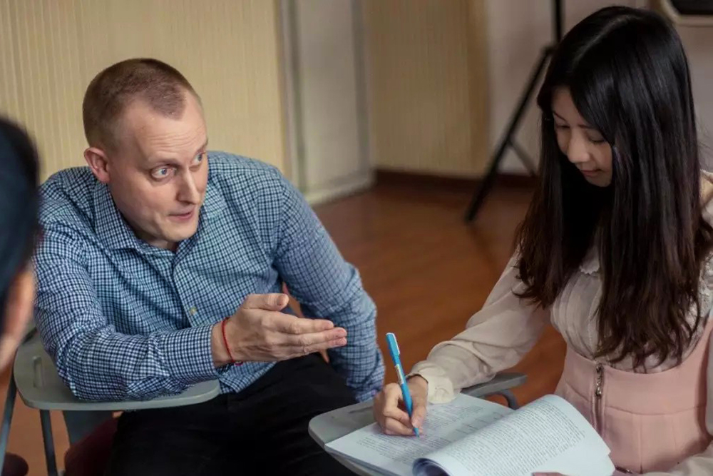 Jeremy Taylor talking to a woman in a classroom environment