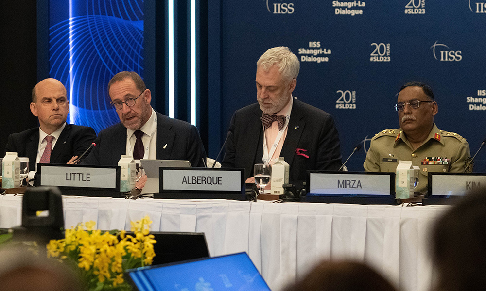 Andrew Little sitting a a table addressing the room