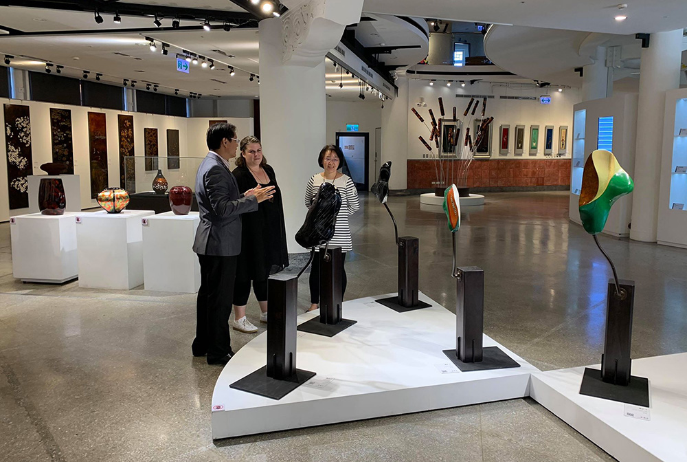 A man talking about a work to Sarah during a tour of the National Taiwanese Craft Research Institute