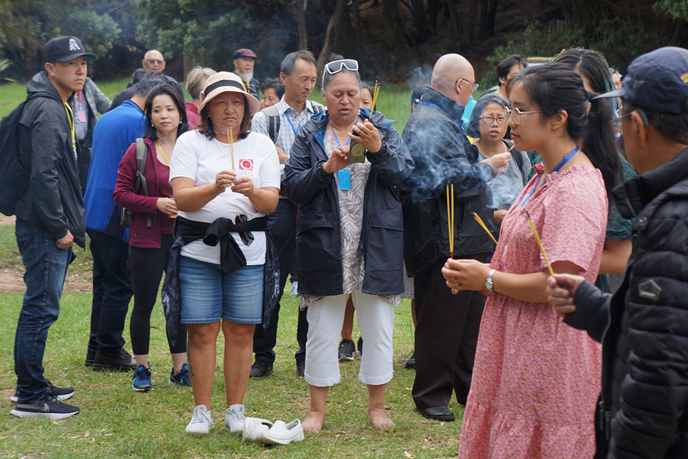 People standing outside lighting incense