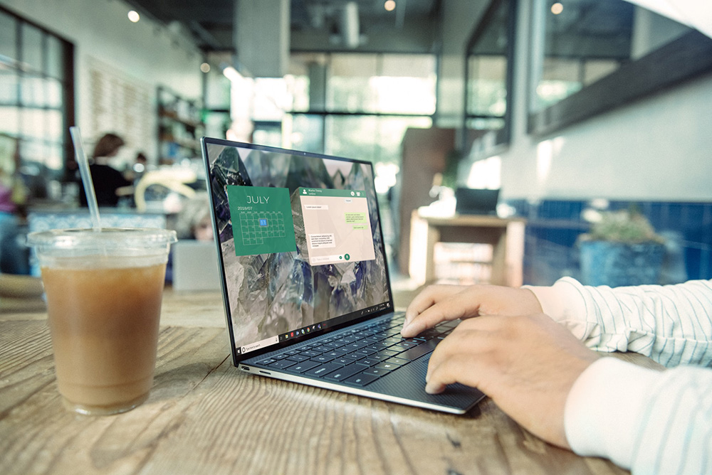 A man working at a laptop in a cafe