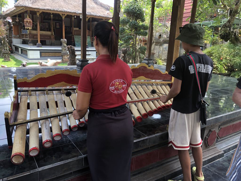 Two people playing a bamboo xylophone