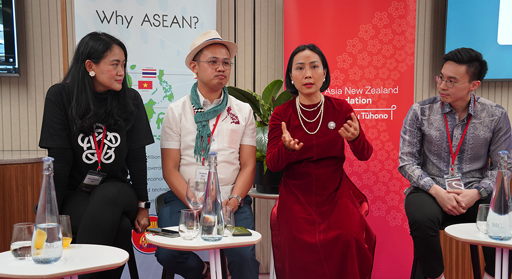 Four of the entrepreneurs on stage as one of them addresses the audience