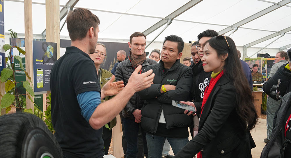 A man speaking to three of the entrepreneurs at Fieldays