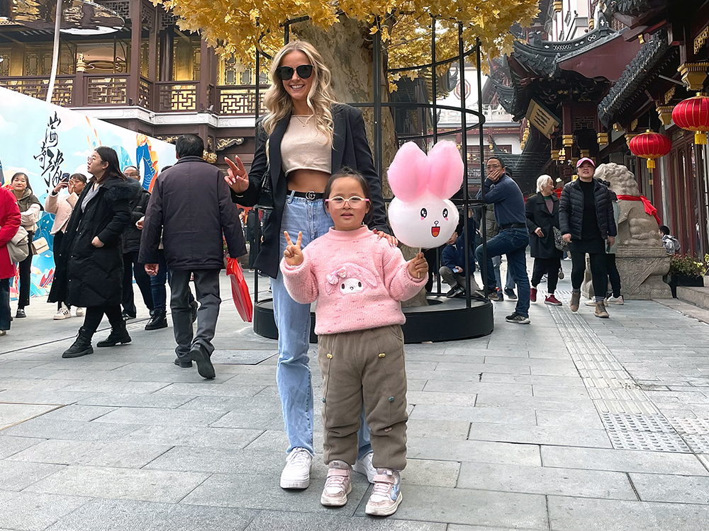 Lori posing for a photo with a small child holding a bunny balloon