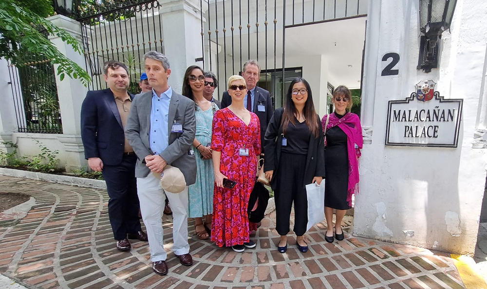 A group of nine New Zealand Journalists posing for a photo outside the Malacanan Palace in Manila