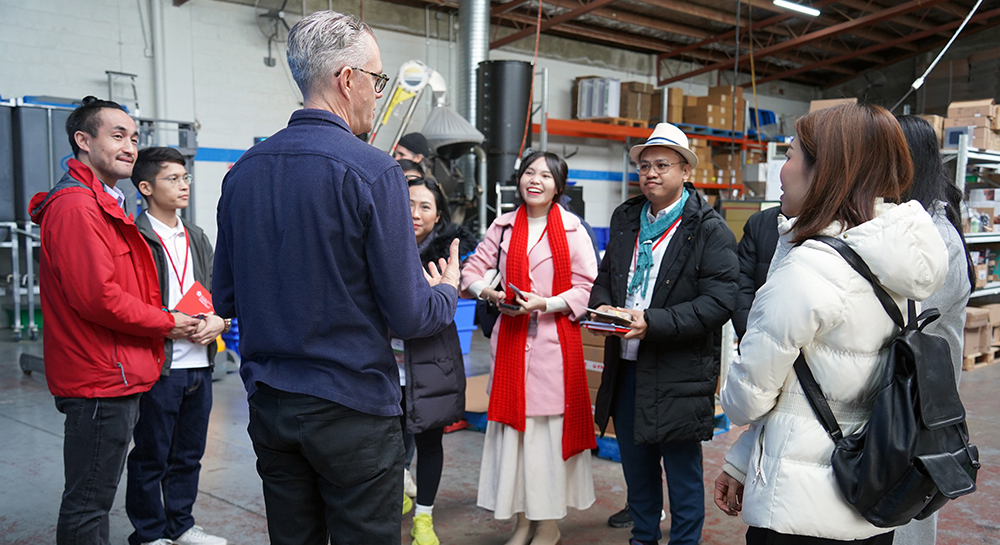 A man speaking to the entrepreneurs in a warehouse