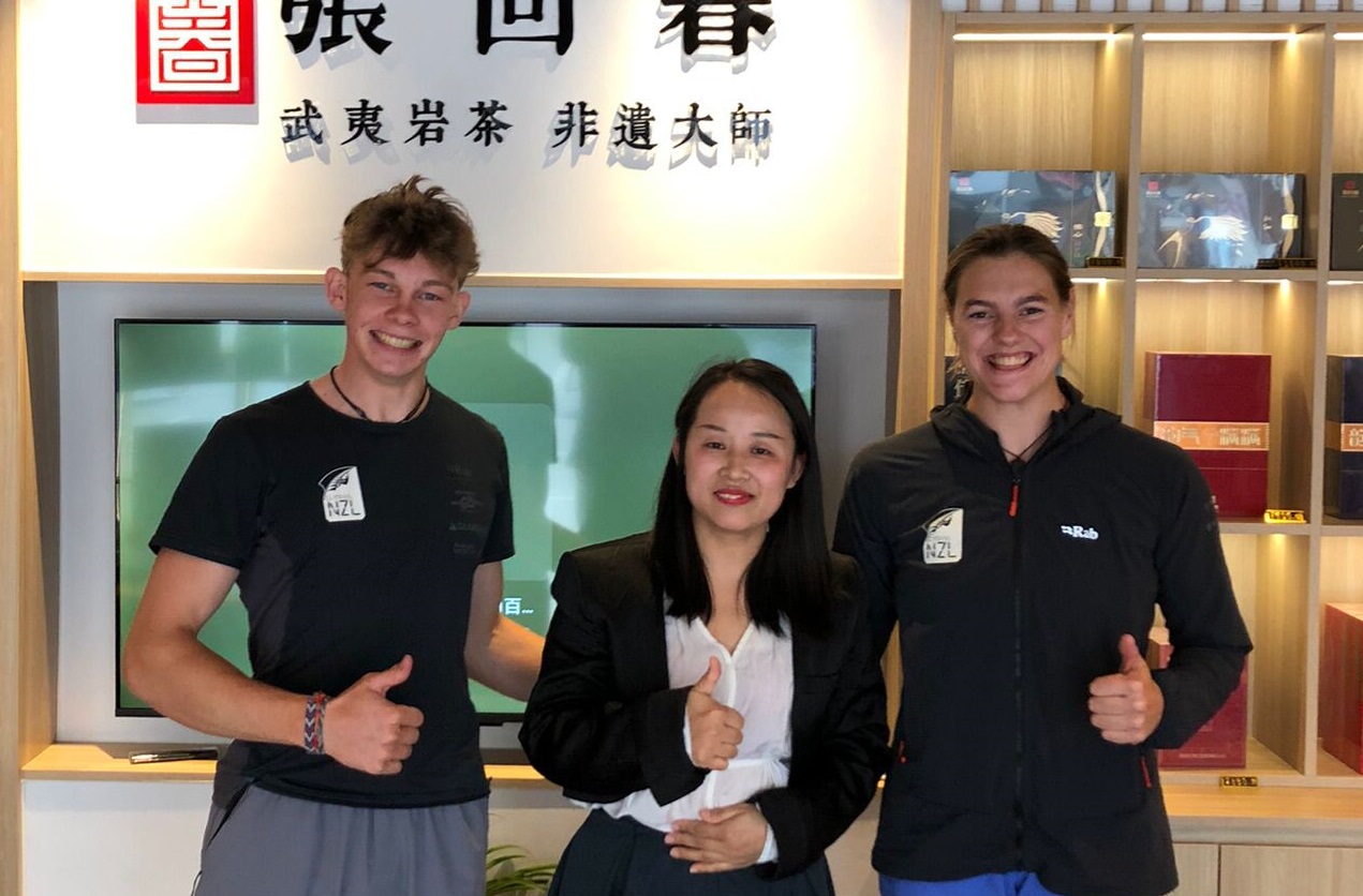 Sarah and Julian standing with a woman in a store giving the thumbs up