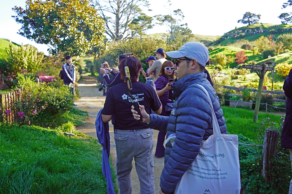 The entrepreneurs walking along a path at Hobbiton taking photos