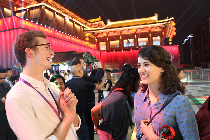 Two Leadership Network members in front of a traditional Chinese building, lit with colourful lights