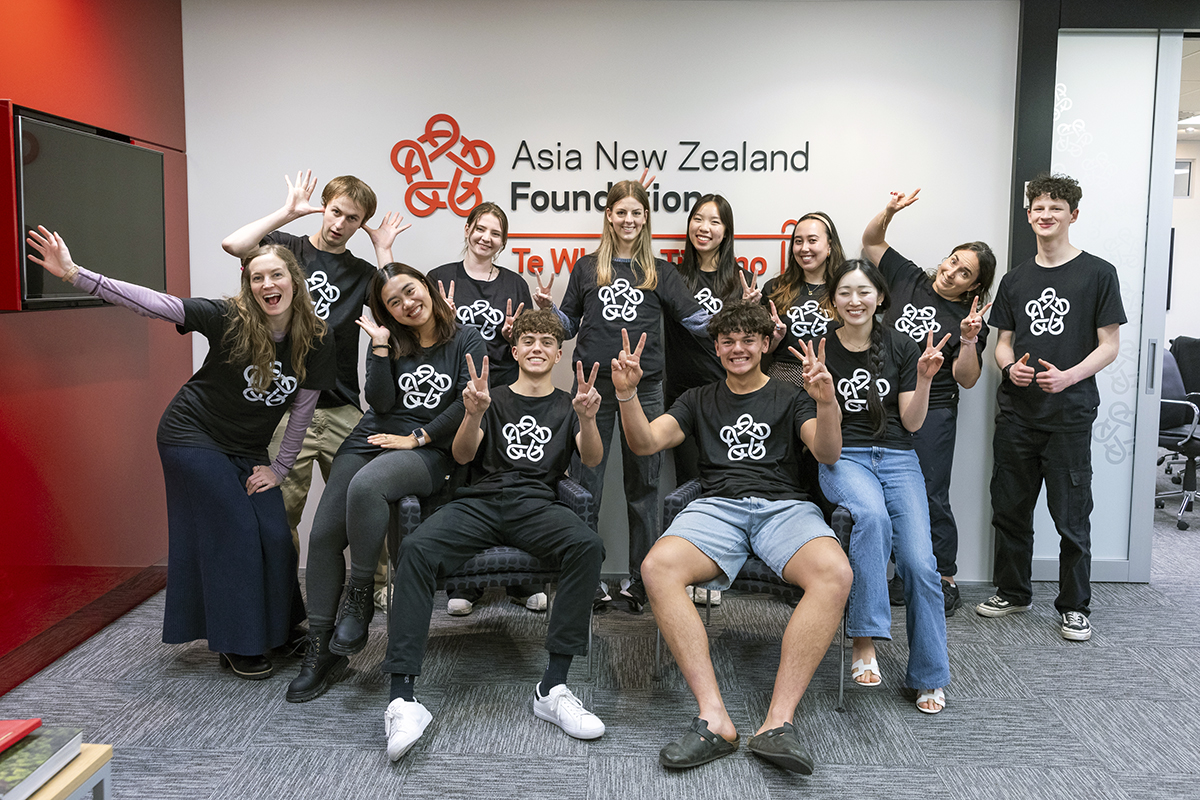 A group of young people in Asia New Zealand Foundation t-shirts posing for a group photo
