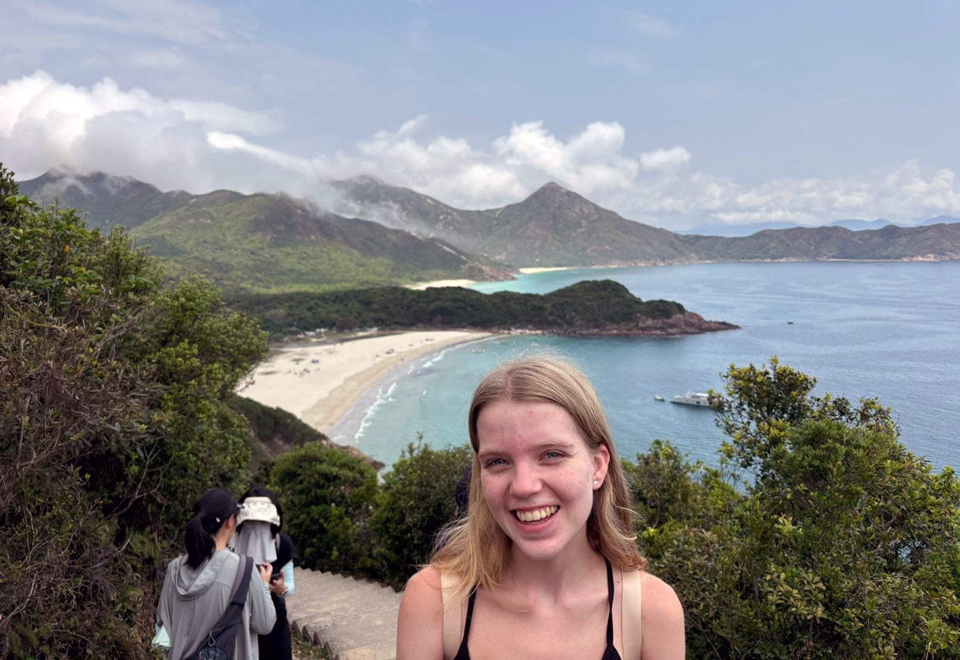 Sian standing on a path with a coastline with beaches stretched out behind her