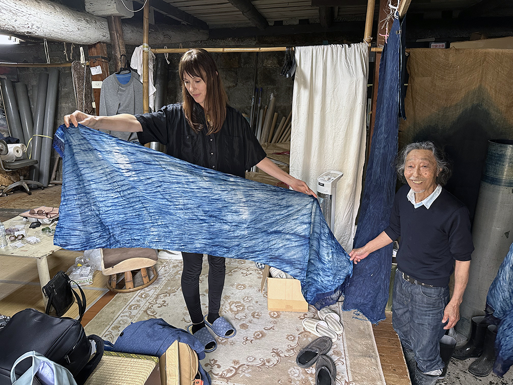 Georgie holding a length of blue material with a man