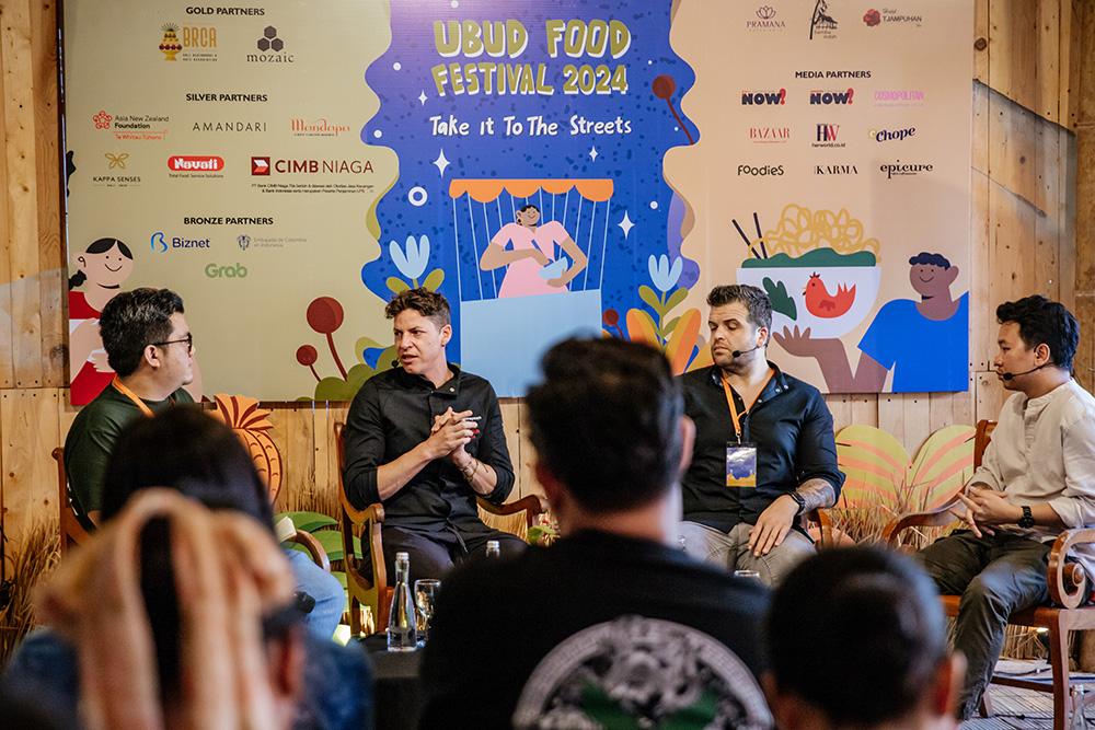 Four chefs giving a talk to a group of attendees