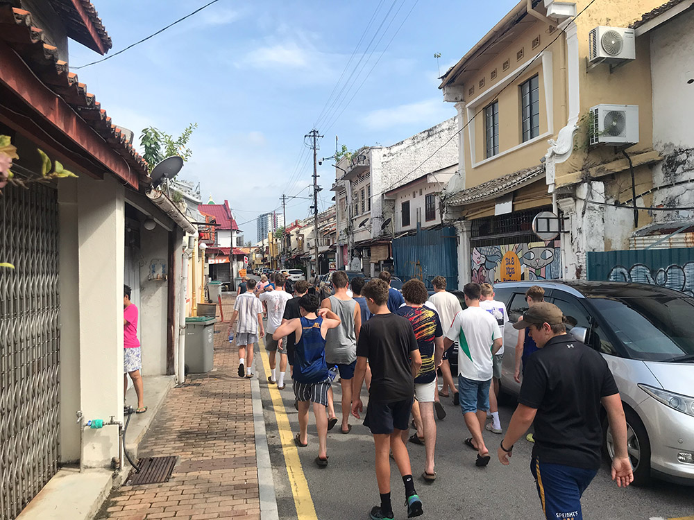 The NZ players walking down a narrow street