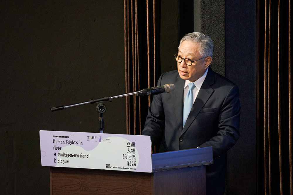 A middle-aged man speaking at a dias