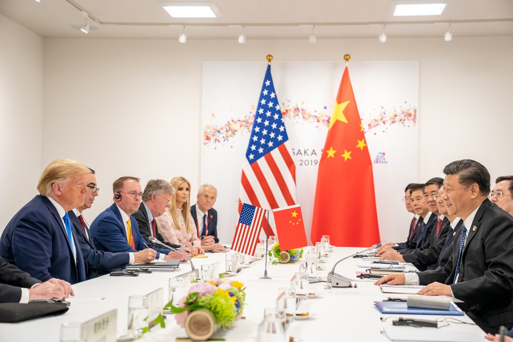 Donald Trump and President Xi looking at each other across a table