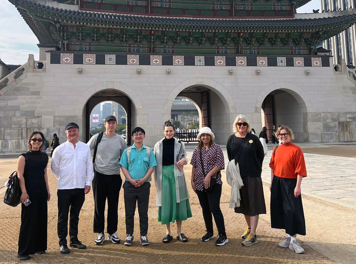 The performing arts delegation posing for a photo in front of Gwanghwamun Gate