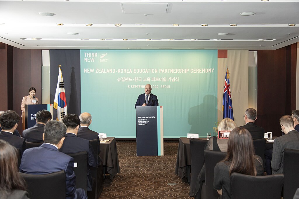 New Zealand Prime Minister John Luxon stading a a podium