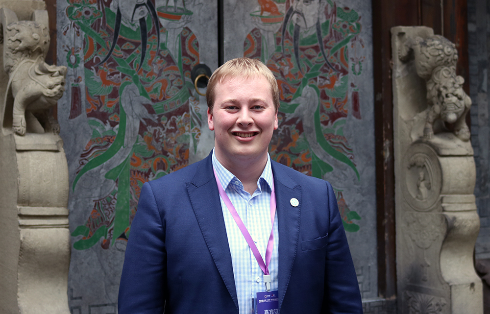 Brad standing in front of an ornate Chinese door