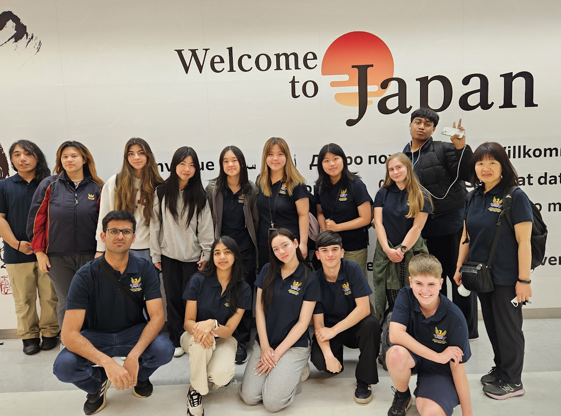 Stdents standing in front of a 'welcome to japan' sign