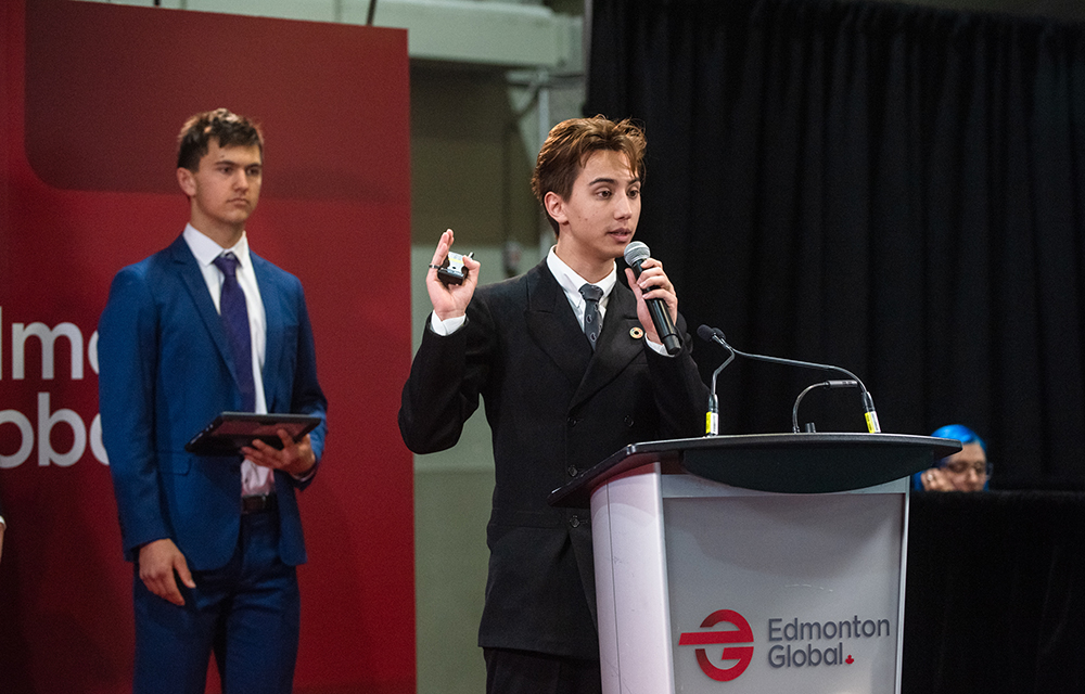 Leonardo at a podium speaking into a microphone
