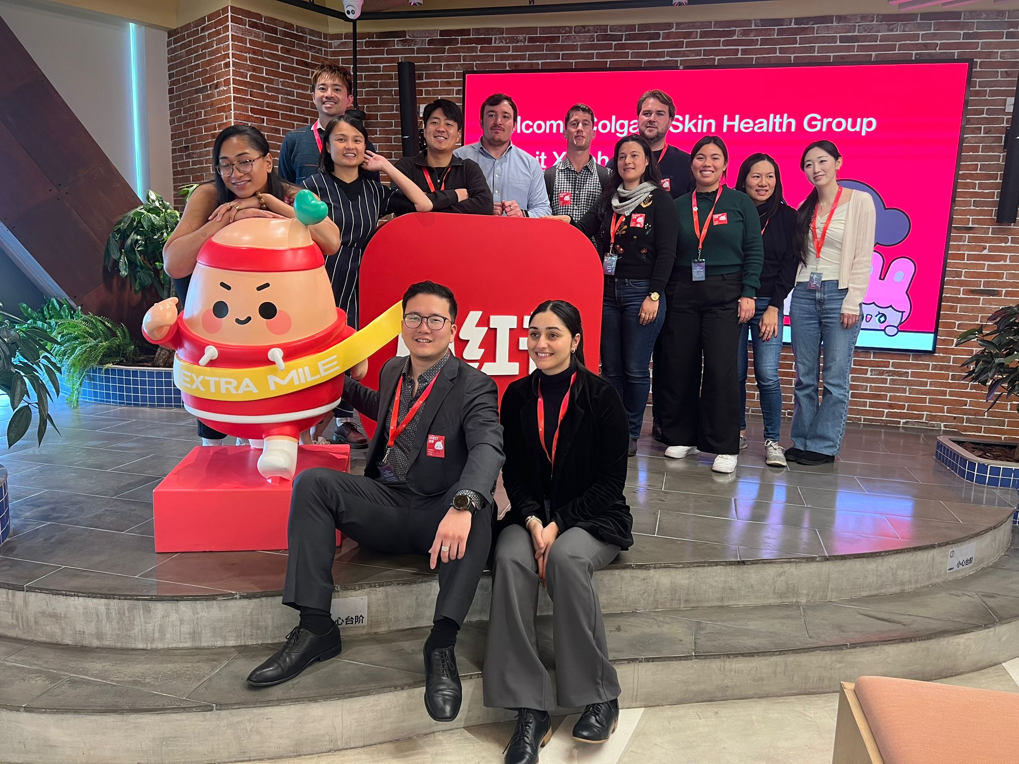 Leadership Network members sitting and standing around a company mascot that looks like an angry egg