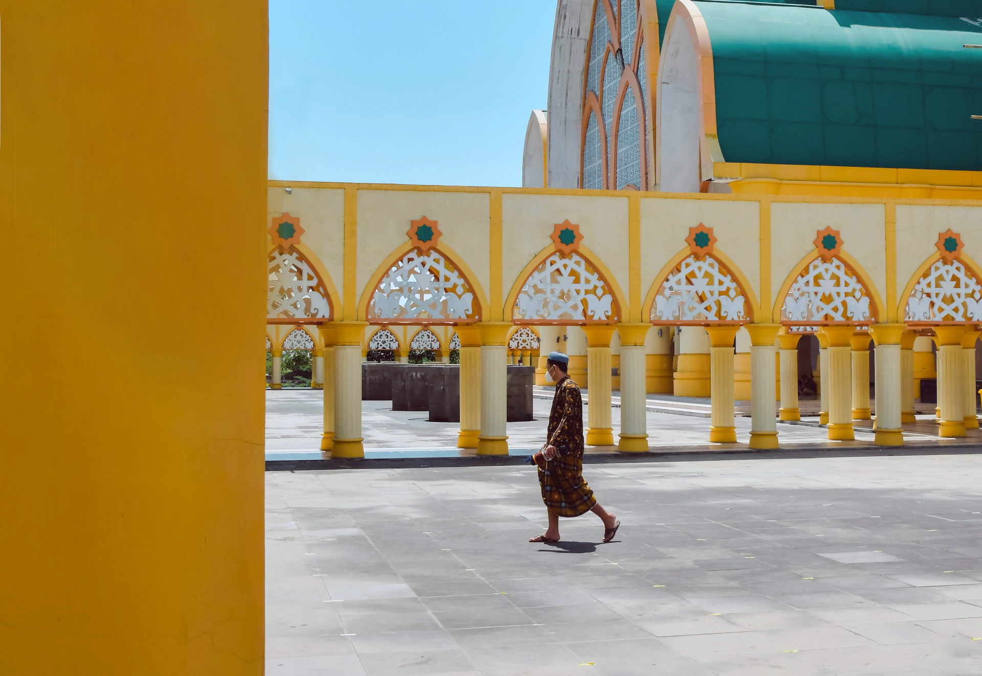 A man walks across the courtyard of a mosque