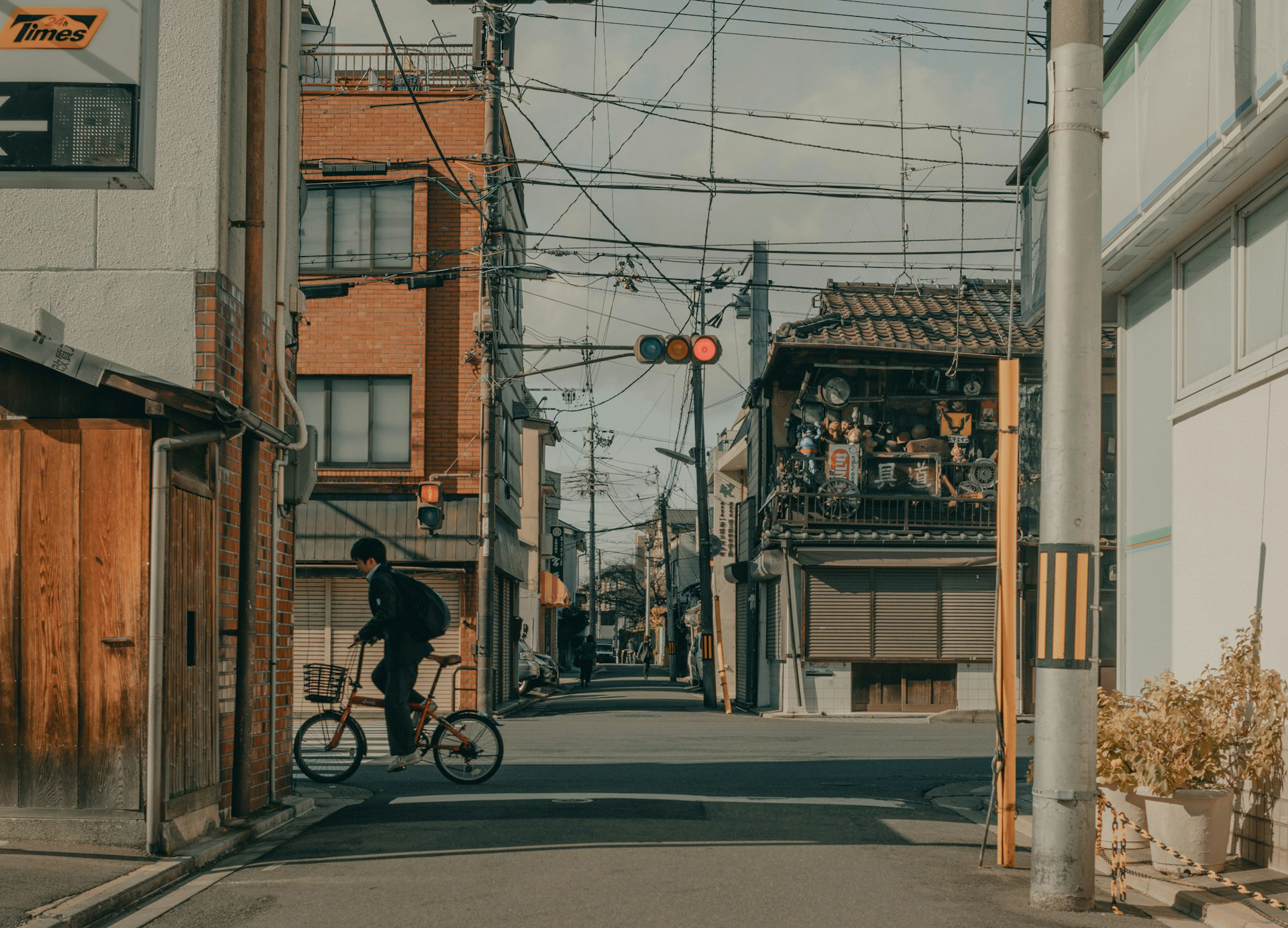 a quiet street with a boy riding a bike across an intersection