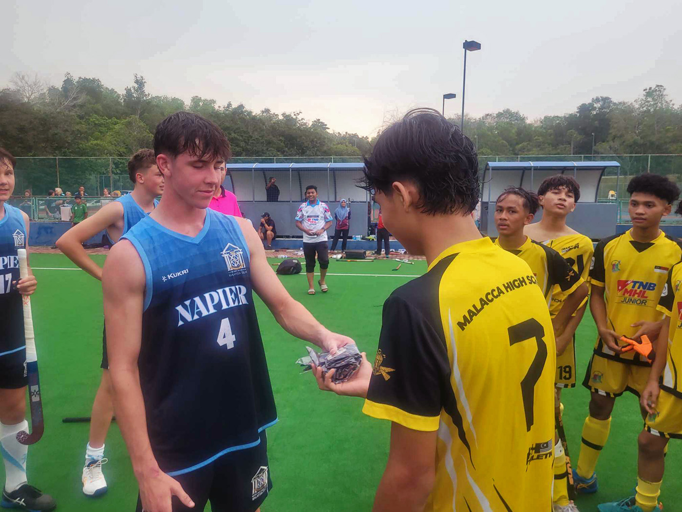 A Napier Boys player exchanging a gift with an opposition player after a game