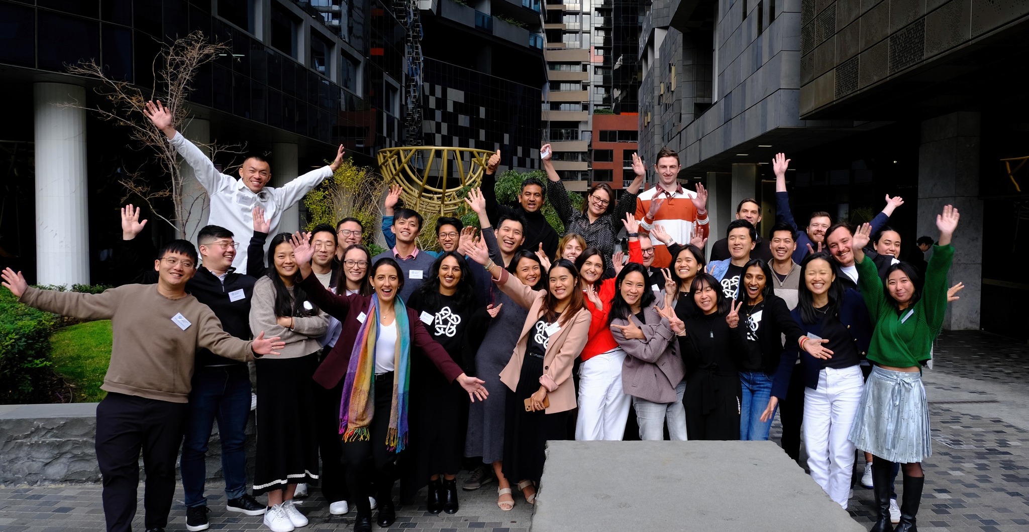 A group photo of the 25-30 Leadership Network members standing in a courtyard