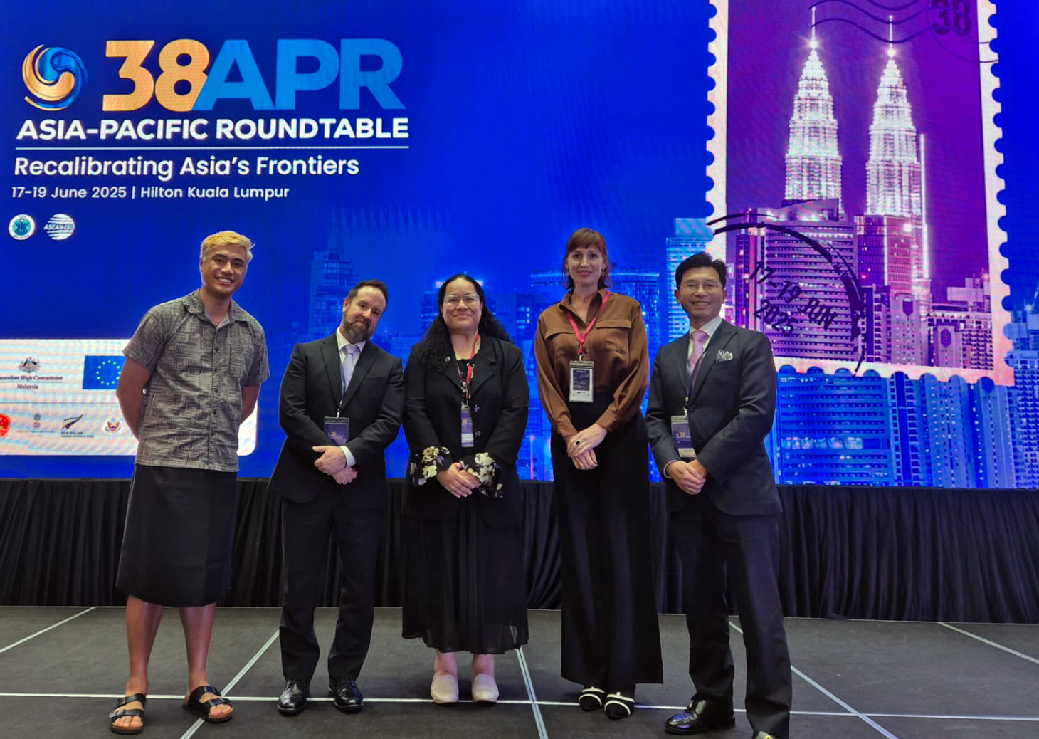 Stephen Noakes with members of the Foundation delegation in front of a large banner for the Asia Pacific Roundtable