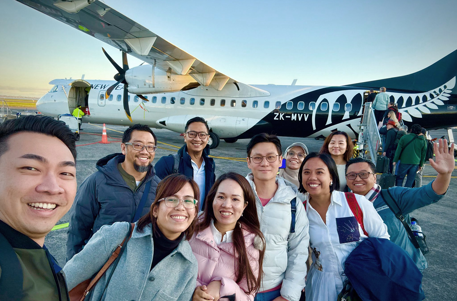 The entrepreneurs standing in front of an Air New Zealand plane