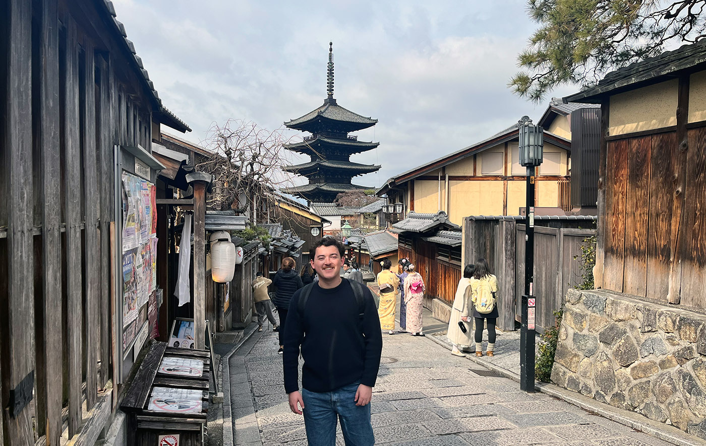 Luca standing on a cobled street with a traditional Japanese pagoda in the background