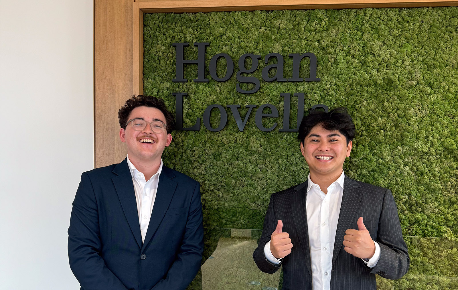 Luca with fellow Hogan Lovells intern Tim Llanes in front of a Hogan Lovells sign